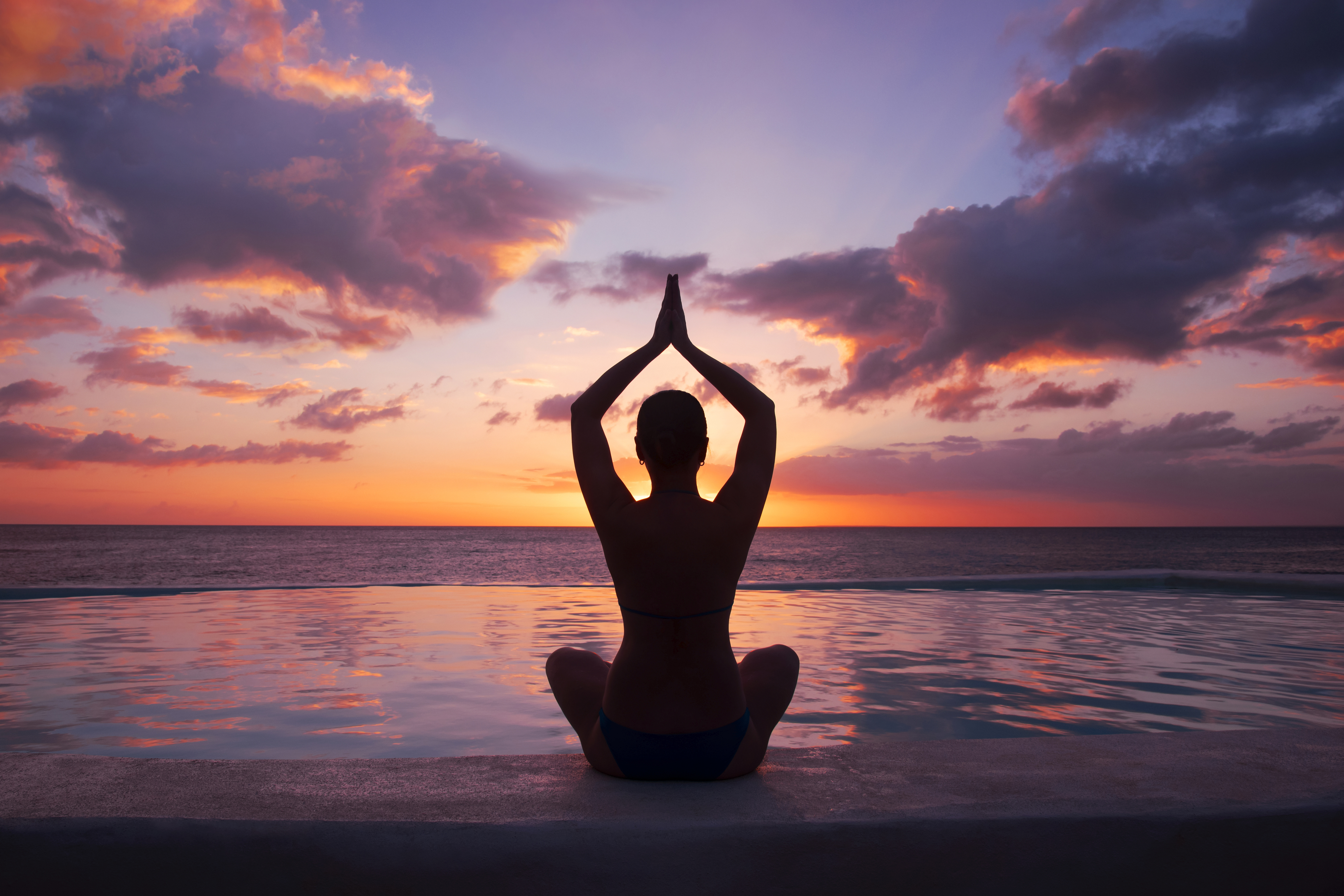 woman-doing-yoga-against-setting-sun.jpg