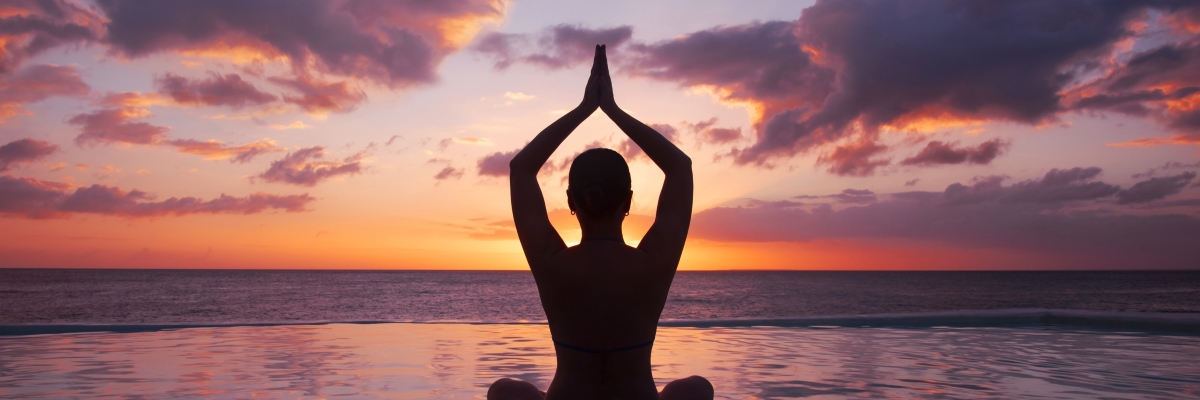 woman-doing-yoga-against-setting-sun_1200x400.jpg